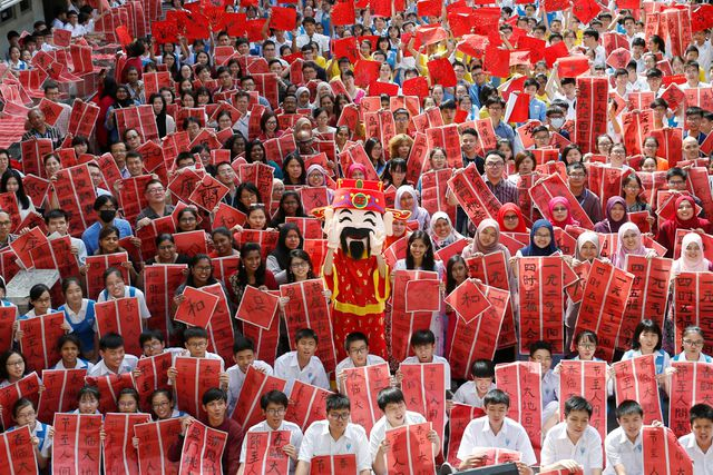 C&aacute;c gi&aacute;o vi&ecirc;n v&agrave; học sinh viết thư ph&aacute;p tại một sự kiện ch&agrave;o mừng năm Kỷ Hợi tại trường phổ th&ocirc;ng Tsun Jin ở Kuala Lumpur, Malaysia. (Ảnh: Reuters)