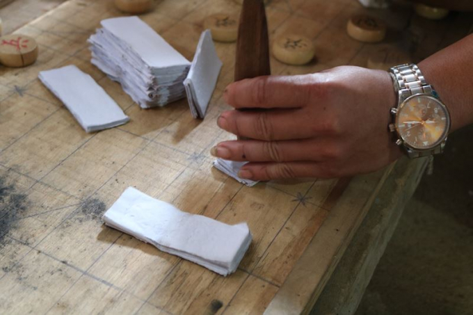 Thầy c&uacute;ng đ&oacute;ng dấu v&agrave;o những tờ giấy được cho l&agrave; tiền &acirc;m phủ.