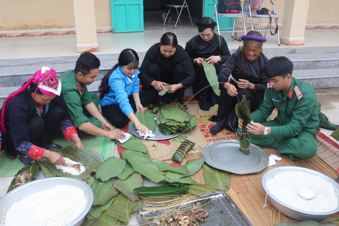 C&aacute;c c&aacute;n bộ chiến sĩ c&ugrave;ng b&agrave; con chung tay g&oacute;i những chiếc b&aacute;nh chưng đầy t&igrave;nh nghĩa qu&acirc;n d&acirc;n.