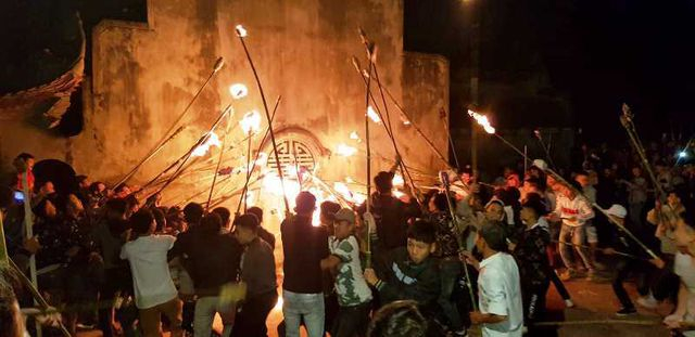 Trong thời khắc giao h&ograve;a giữa trời v&agrave; đất, &aacute;nh lửa thi&ecirc;ng b&ugrave;ng l&ecirc;n s&aacute;ng rực cả một g&oacute;c trời, mọi người chĩa đầu c&acirc;y đuốc v&agrave;o để lấy lửa, sau đ&oacute; giơ cao ngọn đuốc rồi tỏa về khắp c&aacute;c ng&otilde;, x&oacute;m.