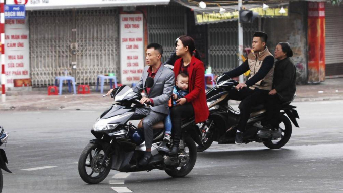 Người d&acirc;n v&ocirc; tư đi xe kh&ocirc;ng đội mũ bảo hiểm trong những ng&agrave;y Tết.&nbsp;