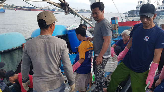 Anh Viện (thứ 2 từ phải qua) đứng c&ugrave;ng bạn thuyền đưa c&aacute; l&ecirc;n bờ.