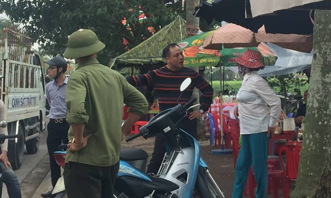 Người phụ nữ được cho l&agrave; c&oacute; h&agrave;nh vi b&oacute;i to&aacute;n, xin tiền bị lực lượng chức năng đưa ra khỏi khu vực đền Trần.