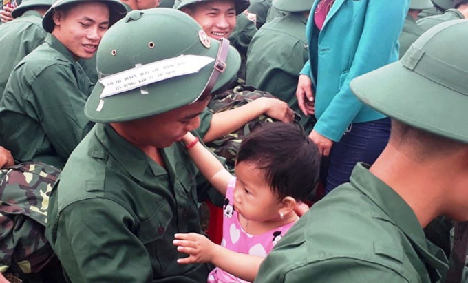 Một t&acirc;n binh &ocirc;m đứa ch&aacute;u g&aacute;i v&agrave;o l&ograve;ng trước l&uacute;c l&ecirc;n đường nhập ngũ