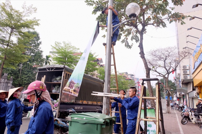 Tr&ecirc;n đường Giảng V&otilde;, c&ocirc;ng nh&acirc;n đang trồng th&ecirc;m c&acirc;y xanh ở giải ph&acirc;n c&aacute;ch.