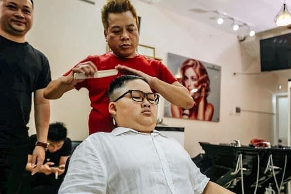 Anh Dương đang cắt t&oacute;c cho kh&aacute;ch h&agrave;ng chọn kiểu t&oacute;c giống ng&agrave;i Kim Jong- un