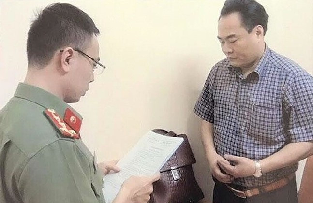 Cơ quan điều tra tống đạt quyết định khởi tố bị can đối với Trần Đức Trung. Ảnh: Tiền Phong.