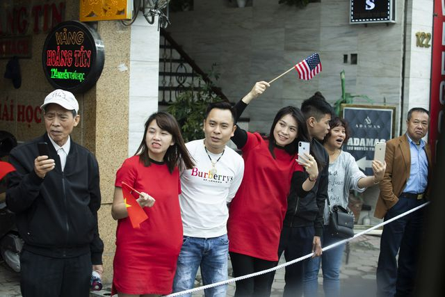 Người d&acirc;n cầm cờ Mỹ đứng hai b&ecirc;n đường ch&agrave;o đ&oacute;n đo&agrave;n xe của Tổng thống Mỹ.&nbsp;