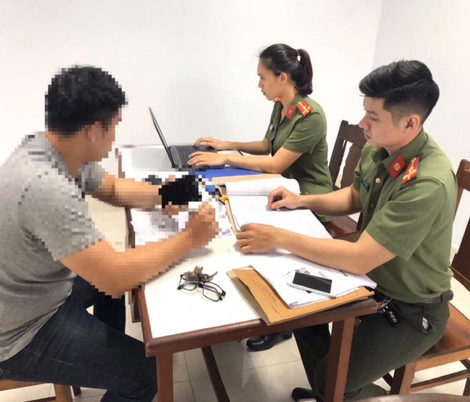 Quản trị viên fanpage Tin nóng Đà Nẵng (trái) làm việc cơ quan công an.
