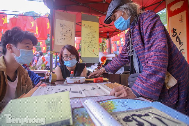  Ông đồ và sĩ tử đeo khẩu trang, đứng giãn cách khi cho chữ, xin chữ.