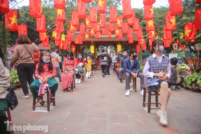 Vì lượng ông đồ ít nên người dân phải xếp hàng chờ đợi, ghế chờ được xếp sẵn giữ khoảng cách tối thiểu 1m.