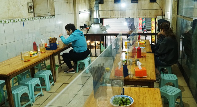 Trên đường Đê La Thành, quán phở lắp vách ngăn để đảm bảo phòng chống dịch.