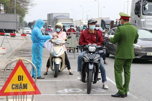 Lực lượng trực chốt kiểm soát cấp tỉnh tại ngã ba Hoàng Long, cửa ngõ phía tây thành phố Hải Dương kiểm tra kỹ giấy tờ của người dân lưu thông qua đây. (Ảnh: Mạnh Minh/TTXVN)