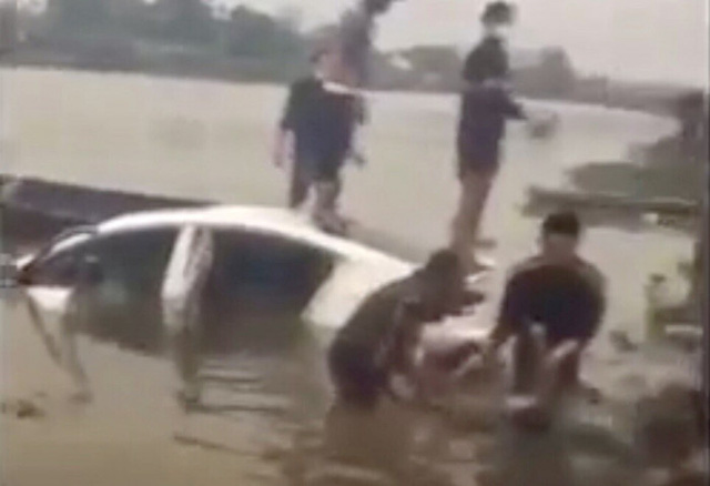 Lực lượng chức năng trục vớt xe ô tô cùng thi thể tài xế.