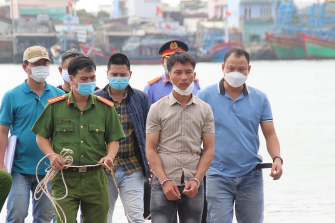 Nghi phạm Trần Văn Viên được dẫn giải đến vị trí ném con của mình xuống sông để thực nghiệm hiện trường.