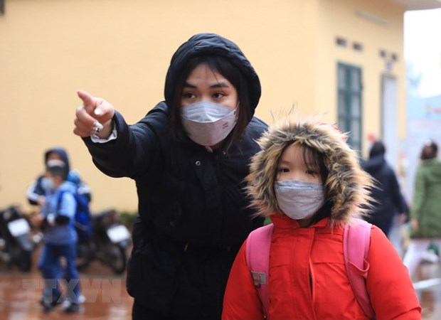 Học sinh được giáo viên hướng dẫn, phân luồng khi tới trường. (Ảnh: TTXVN).