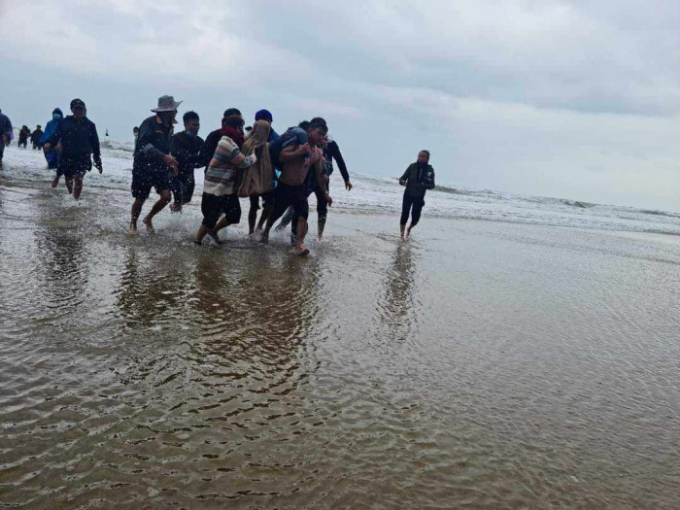 Lực lượng chức năng cùng người dân kịp thời ứng cứu, hỗ trợ đưa các ngư dân chìm thuyền lên bờ.