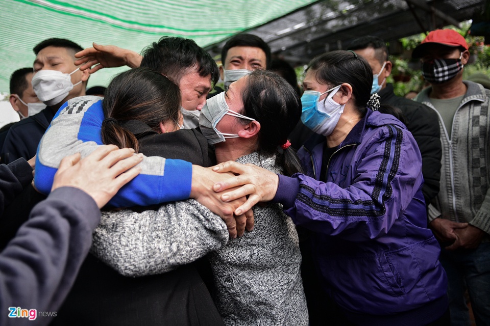 Anh Đương (&aacute;o xanh, bố của hai nạn nh&acirc;n) kh&oacute;c thương trong v&ograve;ng tay những người th&acirc;n.