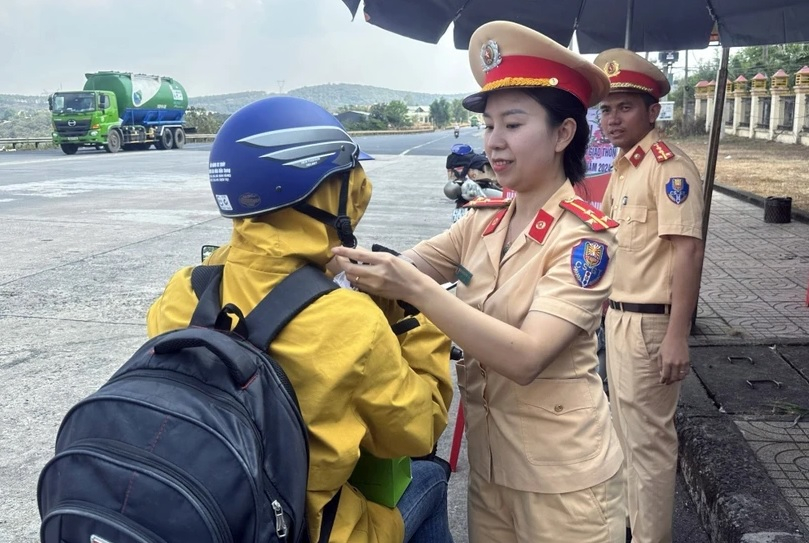 Cảnh sát Giao thông cấp phát mũ bảo hiểm đạt chuẩn cho người dân. (Ảnh: TTXVN phát)