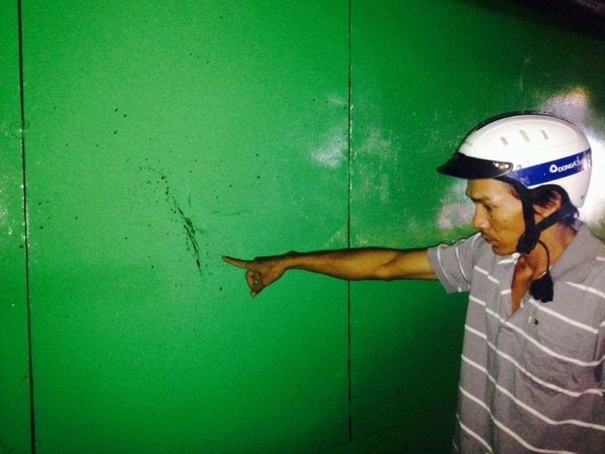 M&aacute;u của nạn nh&acirc;n bắn l&ecirc;n tấm t&ocirc;n ở đầu hẻm 225 đường Kh&aacute;nh Hội. Ảnh: Phạm Thịnh.