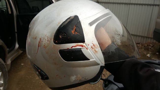 Chiếc mũ bảo hiểm của anh Ho&agrave;ng nhem nhuốc vết m&aacute;u.