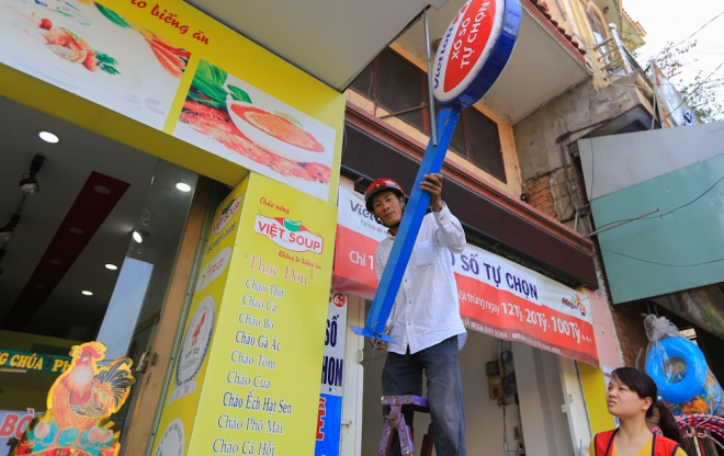 Tr&ecirc;n đường Nguyễn Ảnh Thủ, phường Trung Mỹ T&acirc;y,&nbsp;quận 12, nh&acirc;n vi&ecirc;n cửa h&agrave;ng b&aacute;n v&eacute; số tự chọn đ&atilde; tự gi&aacute;c th&aacute;o bảng hiệu lấn vỉa h&egrave;.