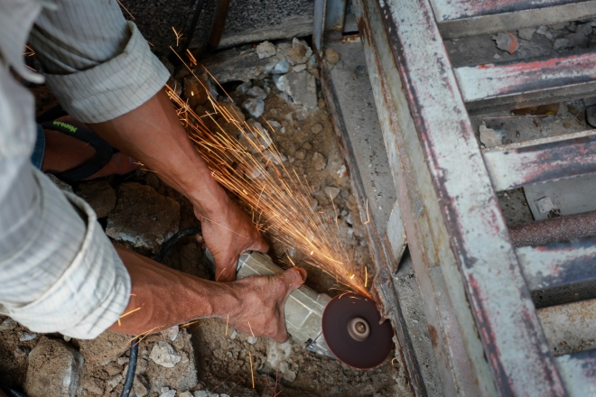 C&aacute;c c&ocirc;ng nh&acirc;n d&ugrave;ng m&aacute;y cắt cầu thang sắt tr&ecirc;n vỉa h&egrave; đường Phan X&iacute;ch Long, quận Ph&uacute; Nhuận.