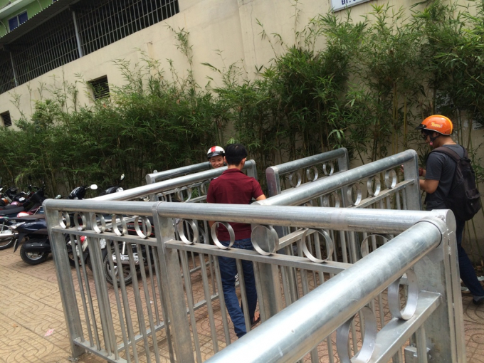 Người đi bộ kh&aacute; vất vả khi v&agrave;o lối đi bộ trong r&agrave;o sắt như