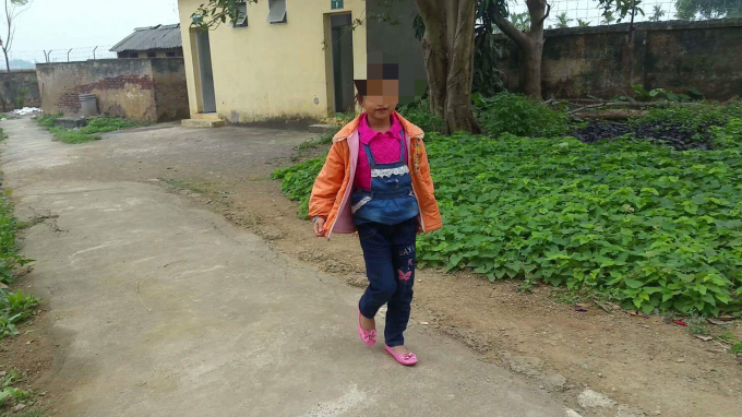 Một học sinh nữ bước vội ra khi m&ugrave;i h&ocirc;i kh&oacute; chịu quanh nh&agrave; vệ sinh g&acirc;y kh&oacute; chịu. Ảnh: Huy Trung.