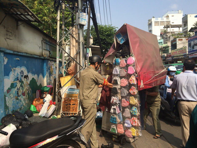 Lực lượng chức năng th&aacute;o dỡ v&agrave; đưa xe b&aacute;n h&agrave;ng rong lấn chiếm vỉa h&egrave; về trụ sở.