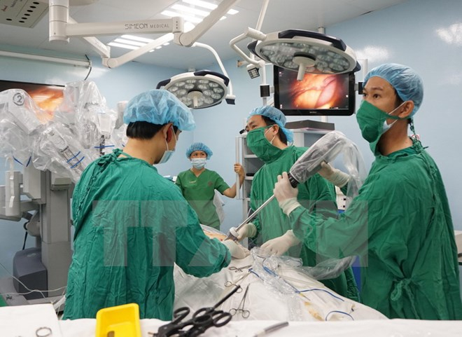 &Ecirc;k&iacute;p b&aacute;c sỹ đưa camera v&agrave;o ổ bụng bệnh nh&acirc;n để chuẩn bị thực hiện phẫu thuật ca ung thư dạ d&agrave;y đầu ti&ecirc;n bằng robot. Ảnh: Phương Vy/TTXVN