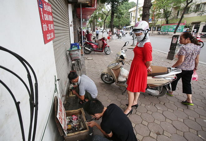 Người thợ sửa kh&oacute;a trước đ&acirc;y ngồi thoải m&aacute;i tr&ecirc;n vỉa h&egrave;, nay phải &eacute;p s&aacute;t ph&iacute;a trong để l&agrave;m kh&oacute;a.