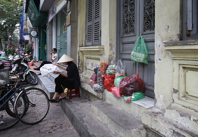Dẹp bớt b&agrave;n ghế, ph&ocirc;ng bạt, người phụ nữ b&aacute;n h&agrave;ng kh&ocirc; b&agrave;y đồ tr&ecirc;n bậc tam cấp của ngồi nh&agrave; ở đường Ng&ocirc; Th&igrave; Nhậm.