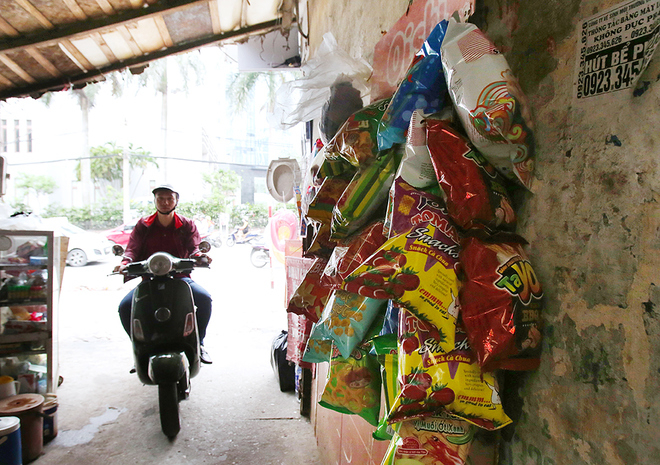 Một qu&aacute;n nước l&ugrave;i v&agrave;o ng&otilde; ở phố C&aacute;t Linh v&agrave; người d&acirc;n tận dựng bức tường để treo đồ.