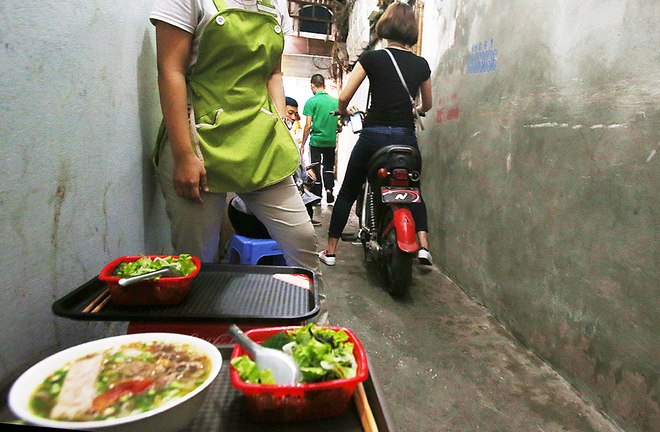 H&agrave;ng ăn s&aacute;ng trong một ng&otilde; nhỏ tr&ecirc;n đường H&agrave;ng B&ocirc;ng, con ng&otilde; n&agrave;y c&oacute; chiều rộng khoảng 80 cm, chỉ đủ k&ecirc; một h&agrave;ng ghế v&agrave; d&agrave;nh phần c&ograve;n lại cho c&aacute;c phương tiện giao th&ocirc;ng.