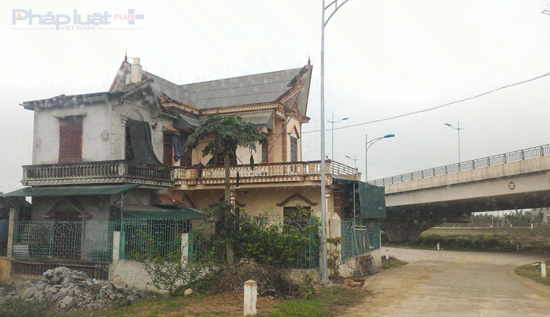 Ng&ocirc;i nh&agrave; 2 tầng đ&atilde; nhận đền b&ugrave;, &aacute;n ngữ tr&ecirc;n h&agrave;ng lang ATGT suốt 3 năm qua g&acirc;y hạn chế tầm nh&igrave;n người tham gia giao th&ocirc;ng. (Ảnh: A.Thắng)