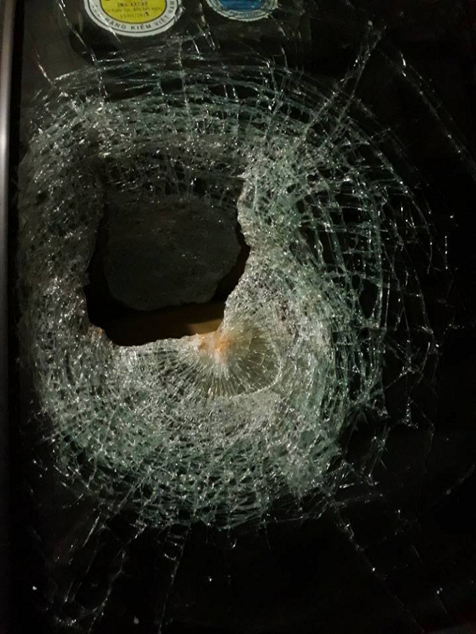 K&iacute;nh xe của anh Ngọc bị thủng một lỗ lỡn sau khi bị n&eacute;m đ&aacute;.