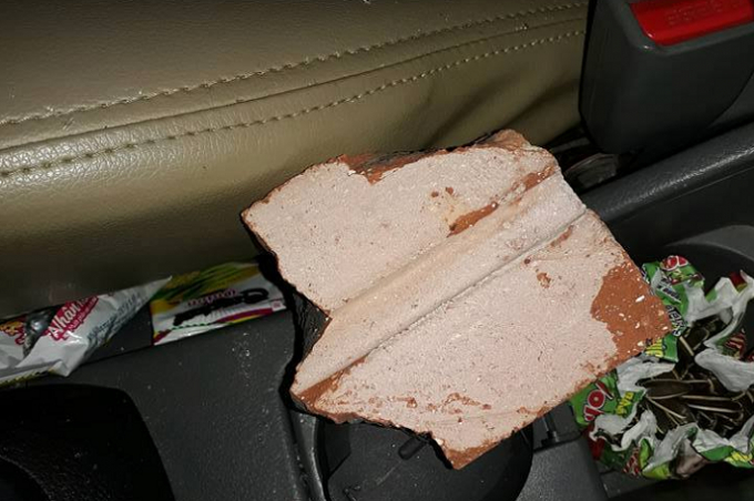 Một phần vi&ecirc;n gạch n&eacute;m v&agrave;o xe của anh Ngọc khiến cả gia đ&igrave;nh hoảng sợ.