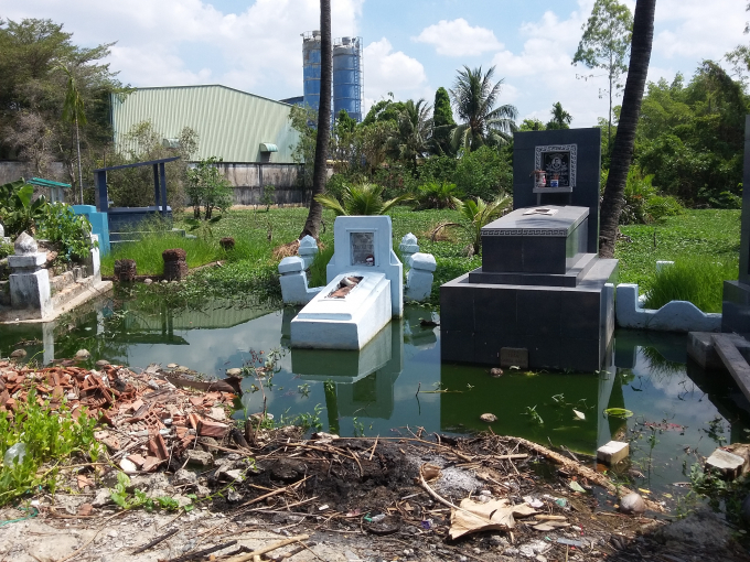 Chất thải g&acirc;y t&ugrave; đọng, nước bẩn ứ th&agrave;nh ao d&acirc;ng v&agrave;o khu vực c&oacute; mộ phần gần đ&oacute;.