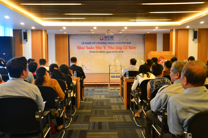 Quang cảnh buổi lễ quay số với sự tham dự của đại diện cơ quan chức năng, l&atilde;nh đạo ng&acirc;n h&agrave;ng v&agrave; đ&ocirc;ng đảo kh&aacute;ch h&agrave;ng.