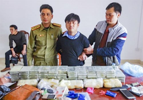 Đối tượng bị bắt giữ c&ugrave;ng tang vật vụ &aacute;n. (Ảnh: b&aacute;o C&ocirc;ng an nh&acirc;n d&acirc;n)