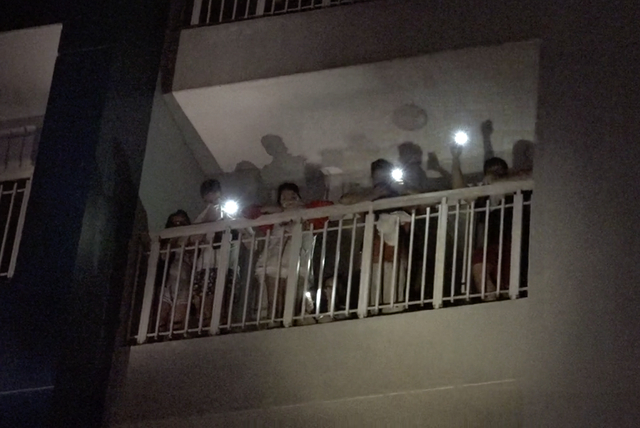 Cư d&acirc;n rọi đ&egrave;n pin cầu cứu ở c&aacute;c tầng cao.