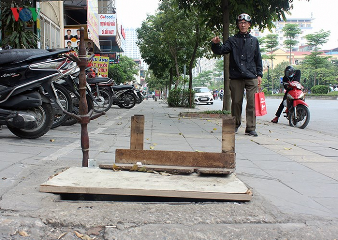 C&aacute;ch đ&oacute; chưa tới 100m, một hố ga lớn cũng bị mất nắp h&agrave;ng năm nay được người d&acirc;n d&ugrave;ng gỗ, gậy che chắn tạm bợ.&nbsp;