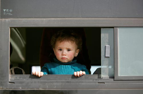 B&eacute; g&aacute;i tr&ecirc;n chiếc xe bu&yacute;t chở qu&acirc;n nổi dậy v&agrave; gia đ&igrave;nh đi sơ t&aacute;n ở đại lộ Harasta, b&ecirc;n ngo&agrave;i khu Jobar thuộc thủ đ&ocirc; Damascus - Syria Ảnh: REUTERS