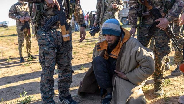 Một tay s&uacute;ng nghi l&agrave; th&agrave;nh vi&ecirc;n của IS đang bị kiểm tra tại thị trấn Baghouz, Syria (Ảnh: AFP)