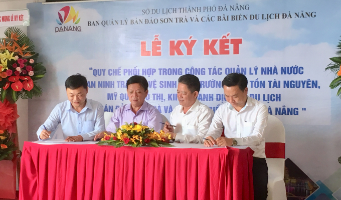 Tr ưởng ban quản l&yacute; B&aacute;n đảo Sơn Tr&agrave; v&agrave; c&aacute;c b&atilde;i biển du lịch TP Đ&agrave; Nẵng Nguyễn Đức Vũ (tr&aacute;i) k&yacute; kết l&atilde;nh đạo c&aacute;c quận trong quy chế phối hợp.