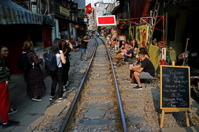 H&agrave;ng ng&agrave;y, những qu&aacute;n c&agrave; ph&ecirc; s&aacute;t đường t&agrave;u đoạn từ đầu phố Trần Ph&uacute; đến phố Ph&ugrave;ng Hưng đ&ocirc;ng nghẹt du kh&aacute;ch ngồi uống c&agrave; ph&ecirc; đợi c&aacute;c đo&agrave;n t&agrave;u đi qua.