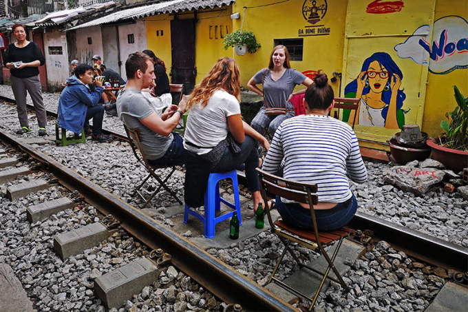 Lượng kh&aacute;ch cực đ&ocirc;ng khiến nhiều người phải k&ecirc; ghế ngồi giữa đường ray uống bia, c&agrave; ph&ecirc;....