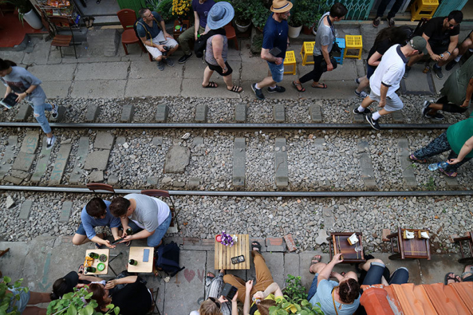 Sau khi đo&agrave;n t&agrave;u chạy qua, c&aacute;c b&agrave;n c&agrave; ph&ecirc; lại được dọn ra như trước đ&oacute;.