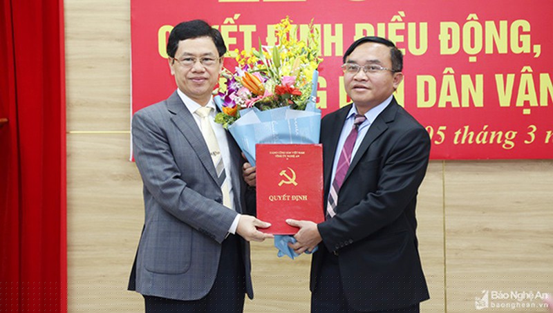 Chủ tịch HĐND tỉnh Nguyễn Xuân Sơn trao quyết định và tặng hoa chúc mừng tân Trưởng Ban Dân vận Tỉnh ủy (ảnh Quốc Sơn - Báo NA)